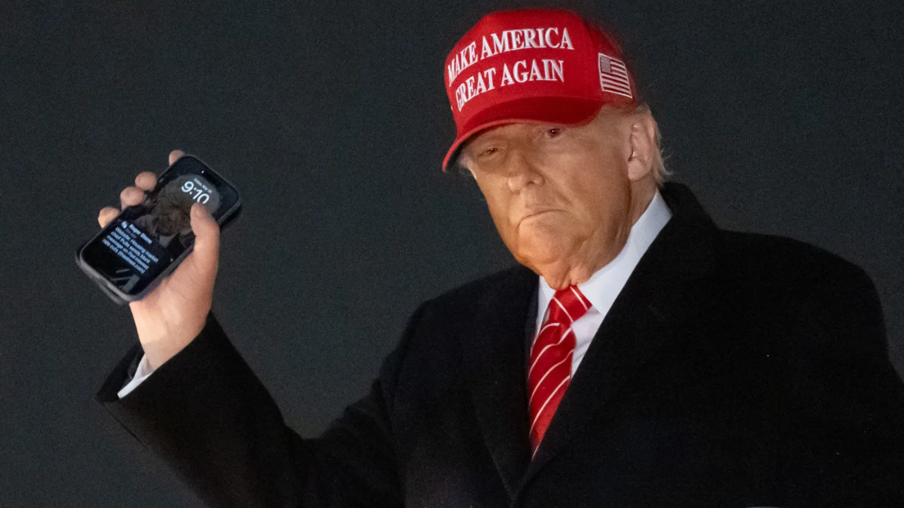 US President Donald Trump disembarks from Air Force One while holding his cellphone with a text message from Roger Stone upon arrival at Joint Base Andrews in Maryland, May 30, 2025, after traveling to Pennsylvania to visit a US Steel plant.